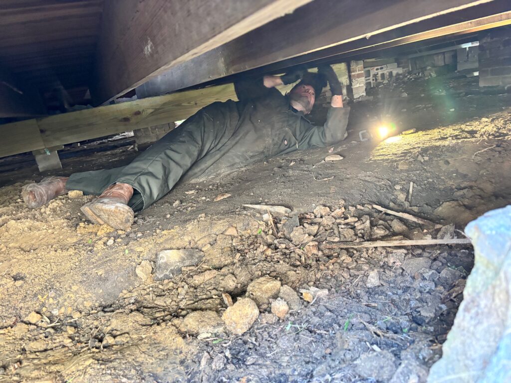 image of justin inspecting the foundation for termite damage